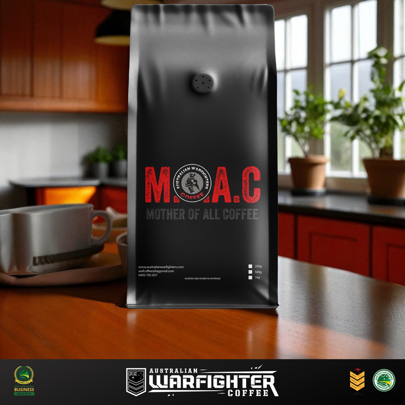 Black coffee bag with 'M.A.C Mother of All Coffee' branding on a kitchen counter.