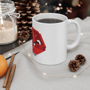 Australian Warfighters Coffee 11oz white ceramic mug with red lips graphic on a cozy table with pinecones and lights